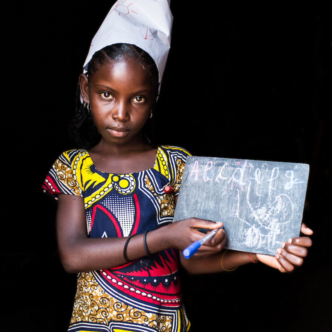 Awa poses dressed up as a teacher, in Carnot, Central African Republic.

In 2013, before the conflict broke out, 67% of children in CAR were attending school. Nowadays, they are much less : it is estimated that 1.4 million children have not yet made their way to school again.